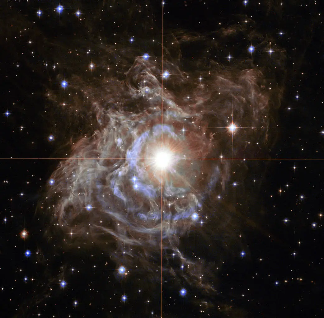 Étoile lumineuse entourée d’une nébuleuse dans un ciel étoilé