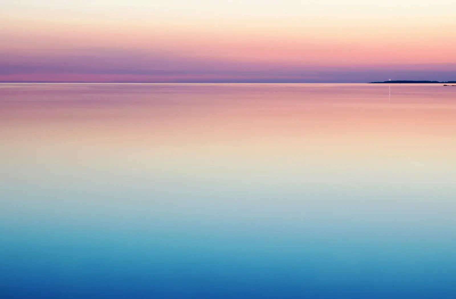Une mer calme sous un ciel rose et bleu